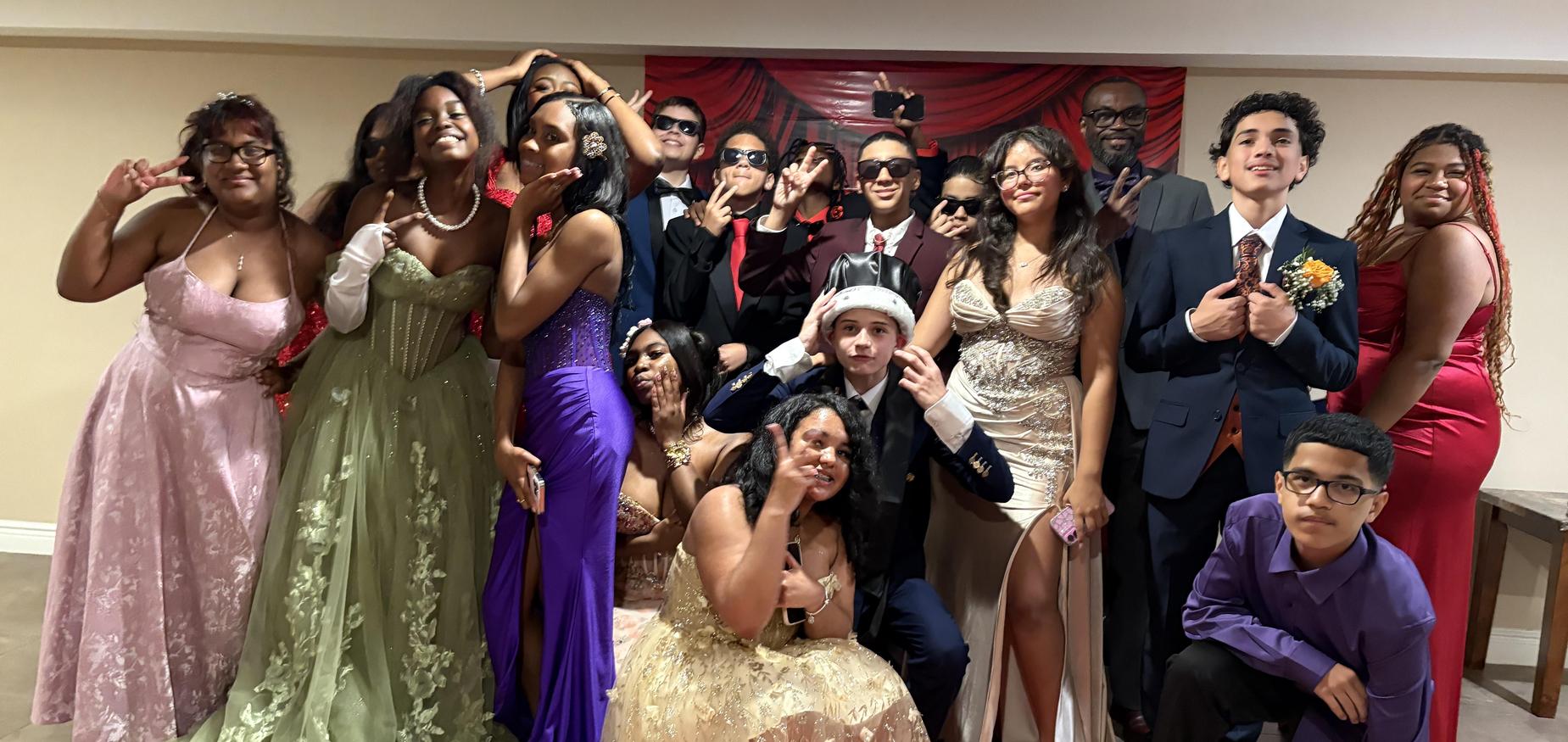Group of students dressed up in prom dresses and suits