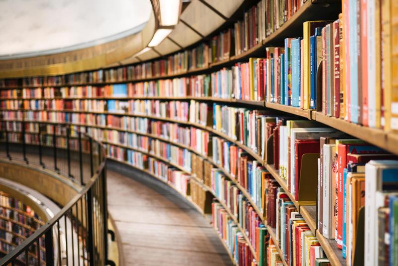 Curved library shelves filled with colorful books.