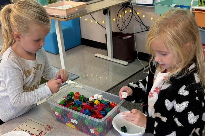 Two students select colorful blocks from a bin to count
