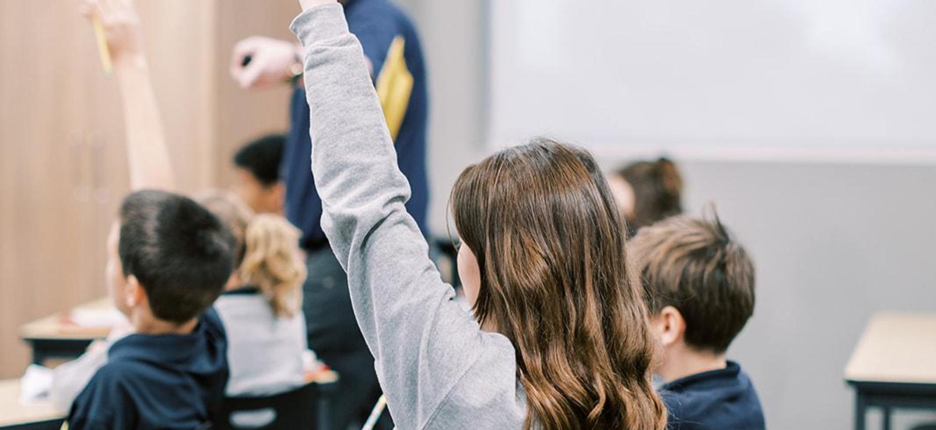 Elementary student raises her hand during class