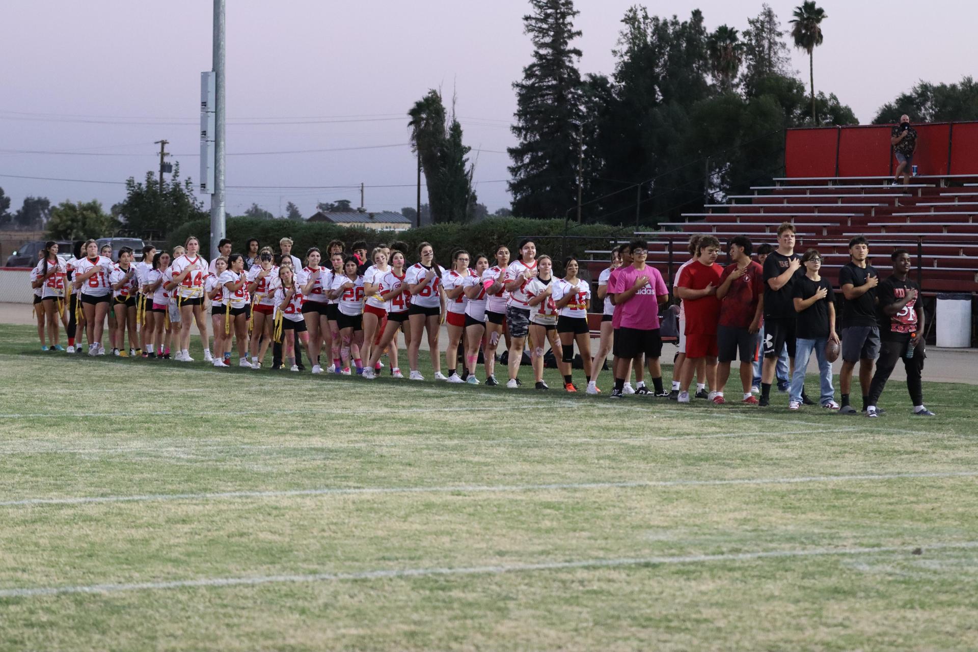players, cheerleaders, and officials preparing for the powderpuff football game