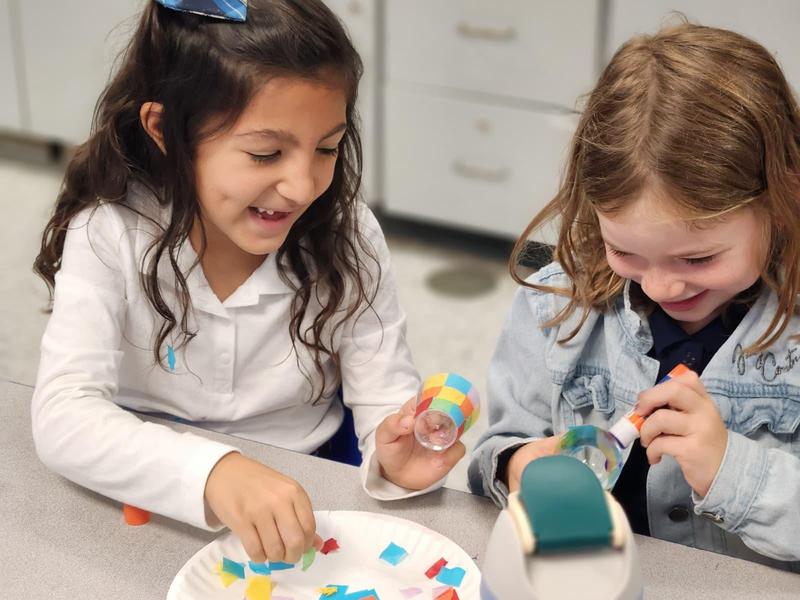 Two first grade students working on a honey dish
