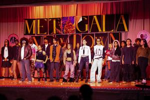 students on a stage with orange/red lighting