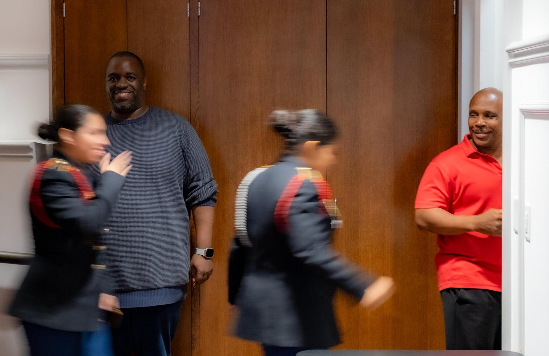 Teachers looking at students with pride at hallway