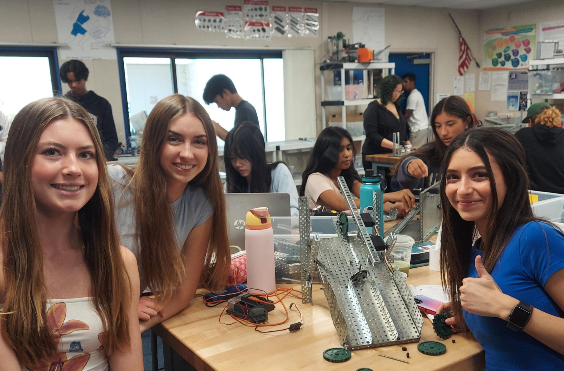 Engineering students smiling and building