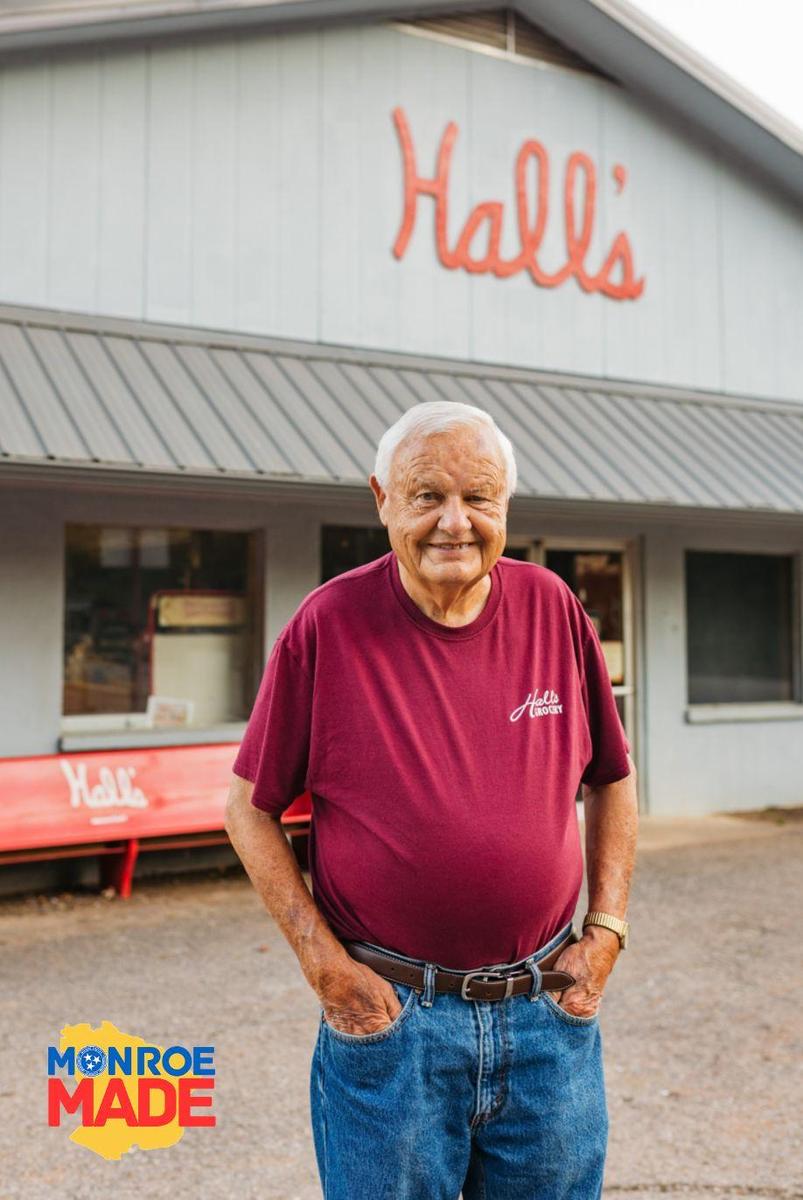 Charlie Hall standing in front of Hall’s Grocery building