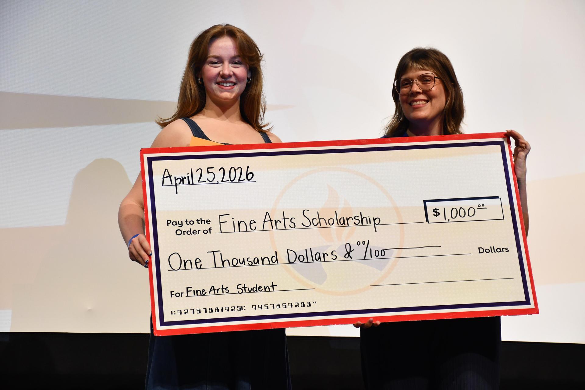 student holding large check