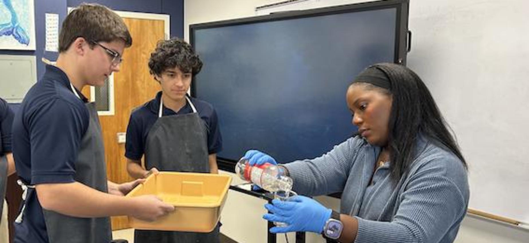 Biology teacher Crystal Stovall helps students with a class experiment.