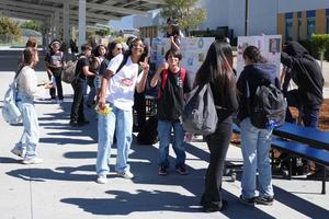 student outside at school looking at college displays
