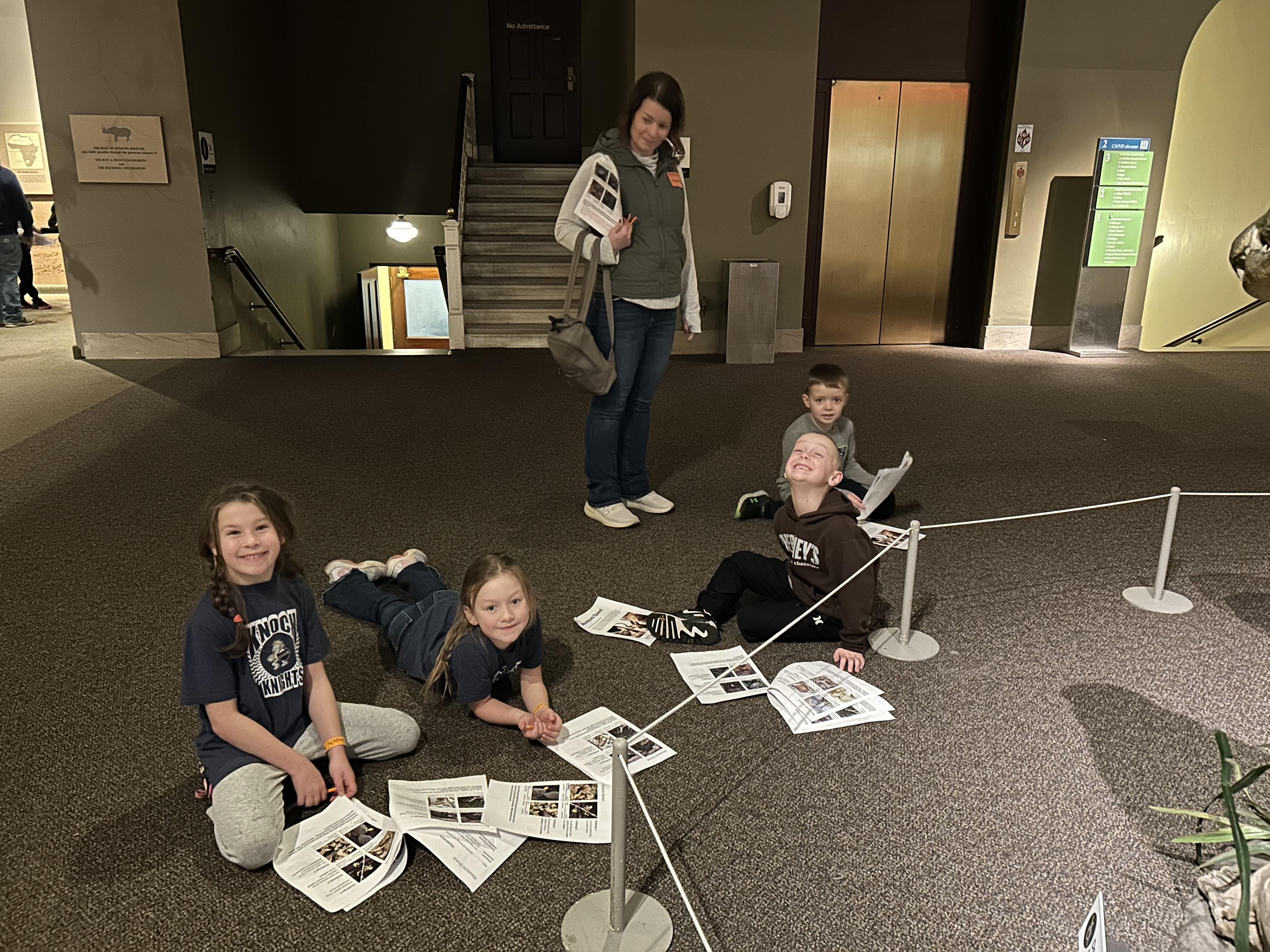 students working on floor of museum