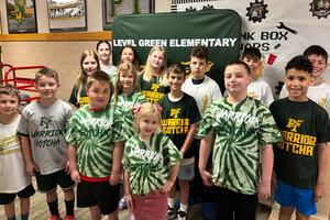 15 students who earned the Gotcha award stand in a group wearing their new shirts