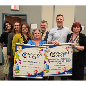 WSWHE BOCES and SUNY Adirondack staff receiving Champions of Change banner from South Glens Falls Board President and NYSSBA Representative John Farrell.