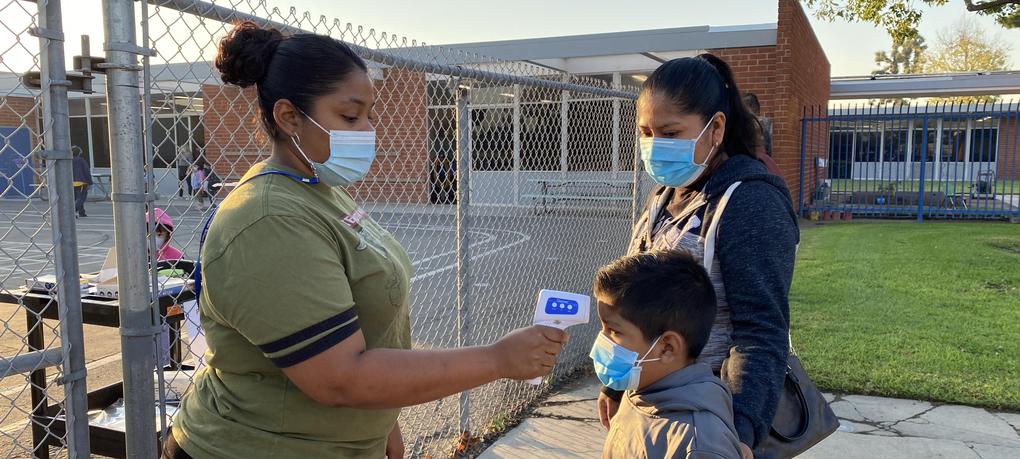 A student gets his temperature checked.