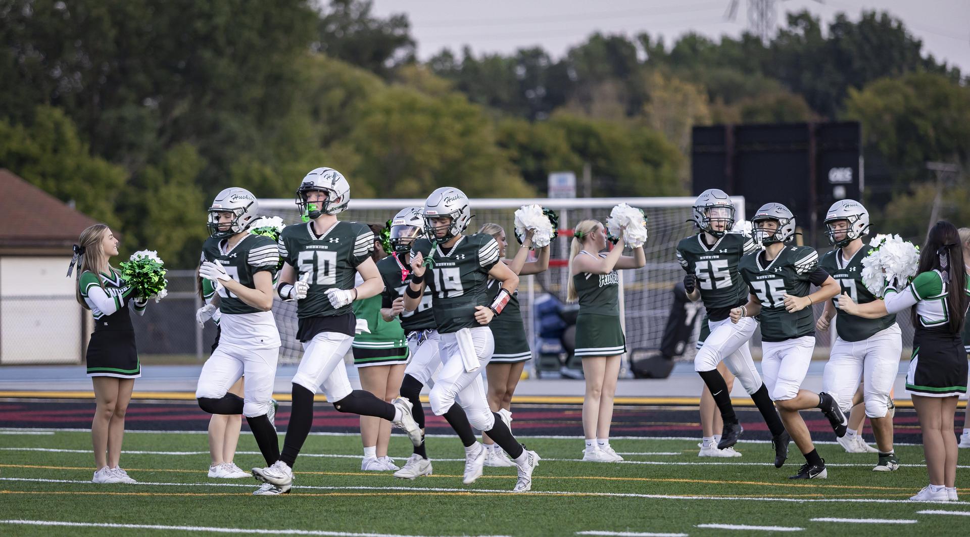 Football team running onto the field for a game
