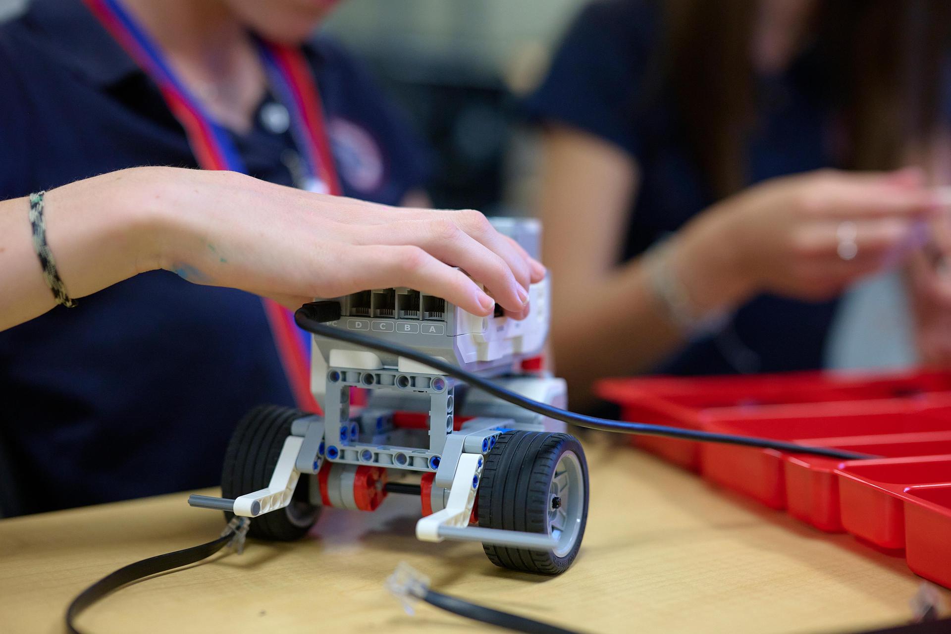 close up of LEGO robotics with student hand placed on it