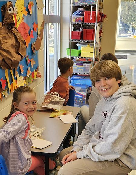 eighth grader working with a kindergartener on reading