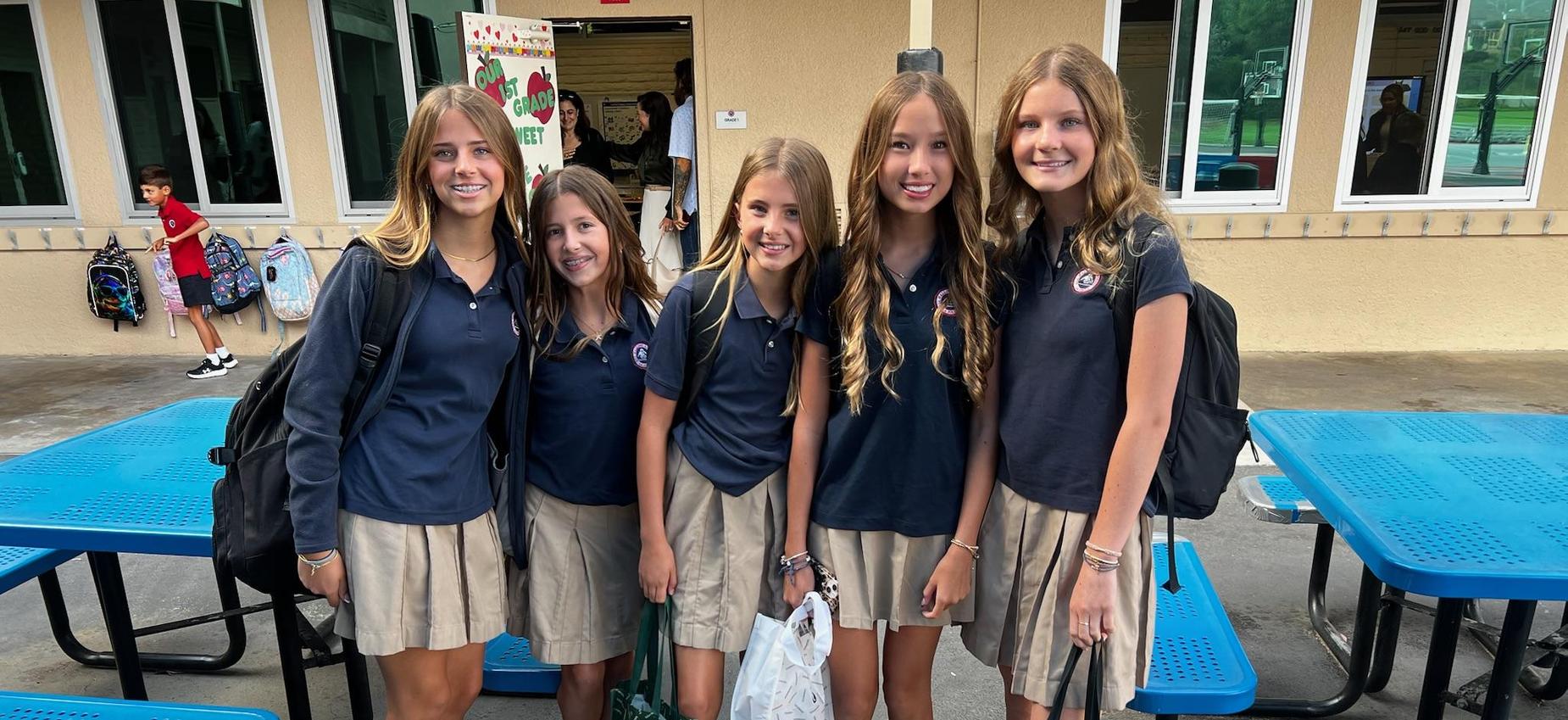 middle school girls pose at lunch tables on the first day of school