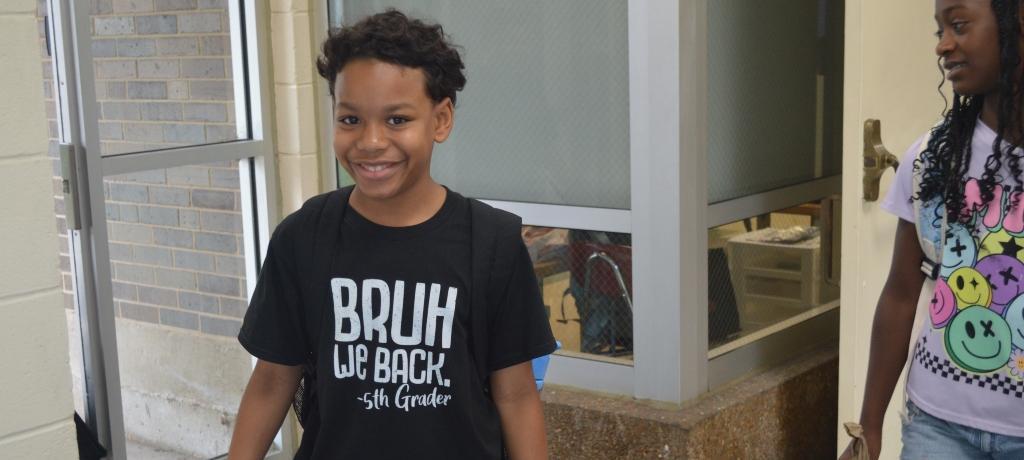 Student in t-shirt that says, "Bruh, We Back. 5th-grader."