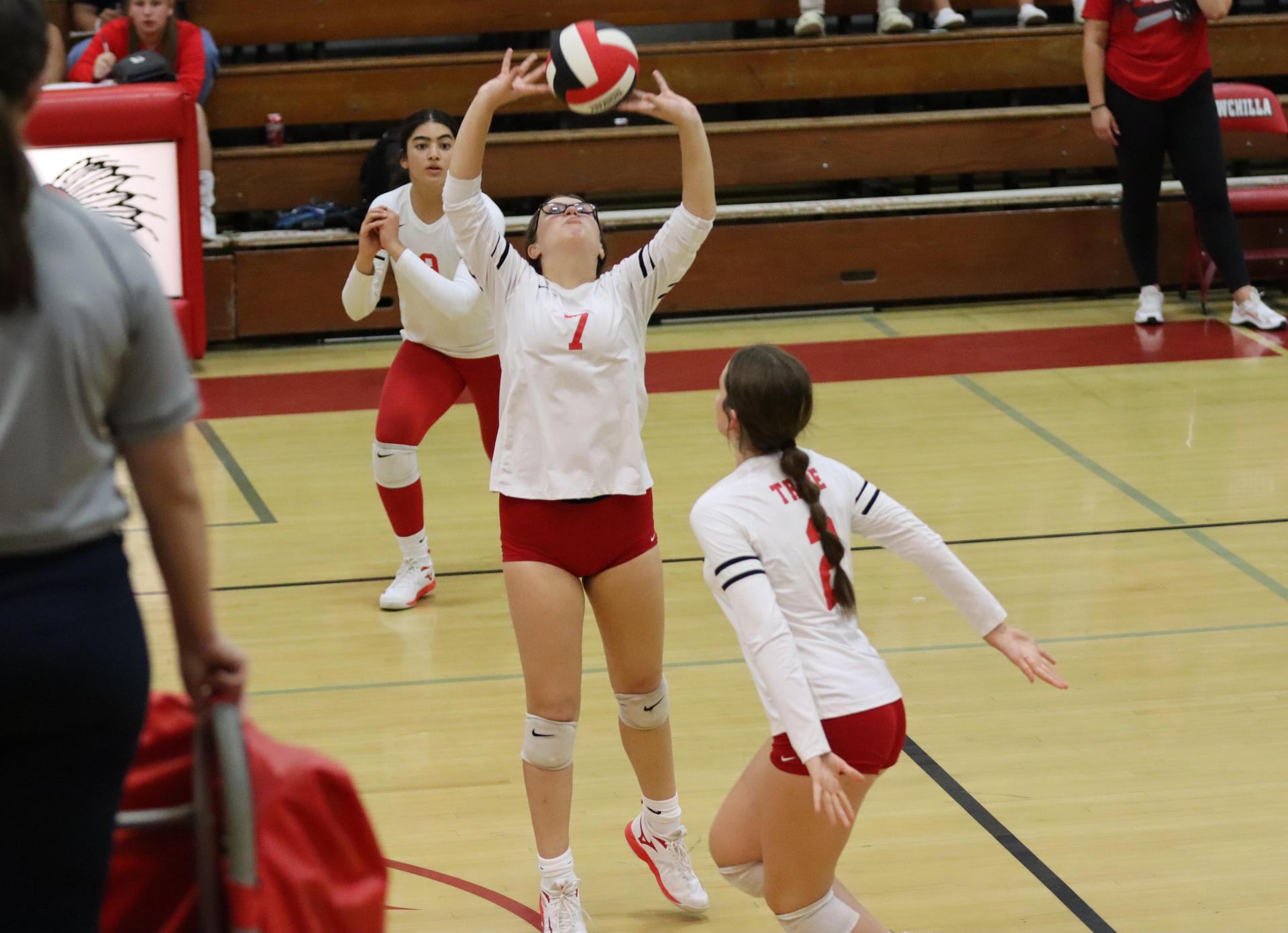 varsity volleyball players in action against liberty