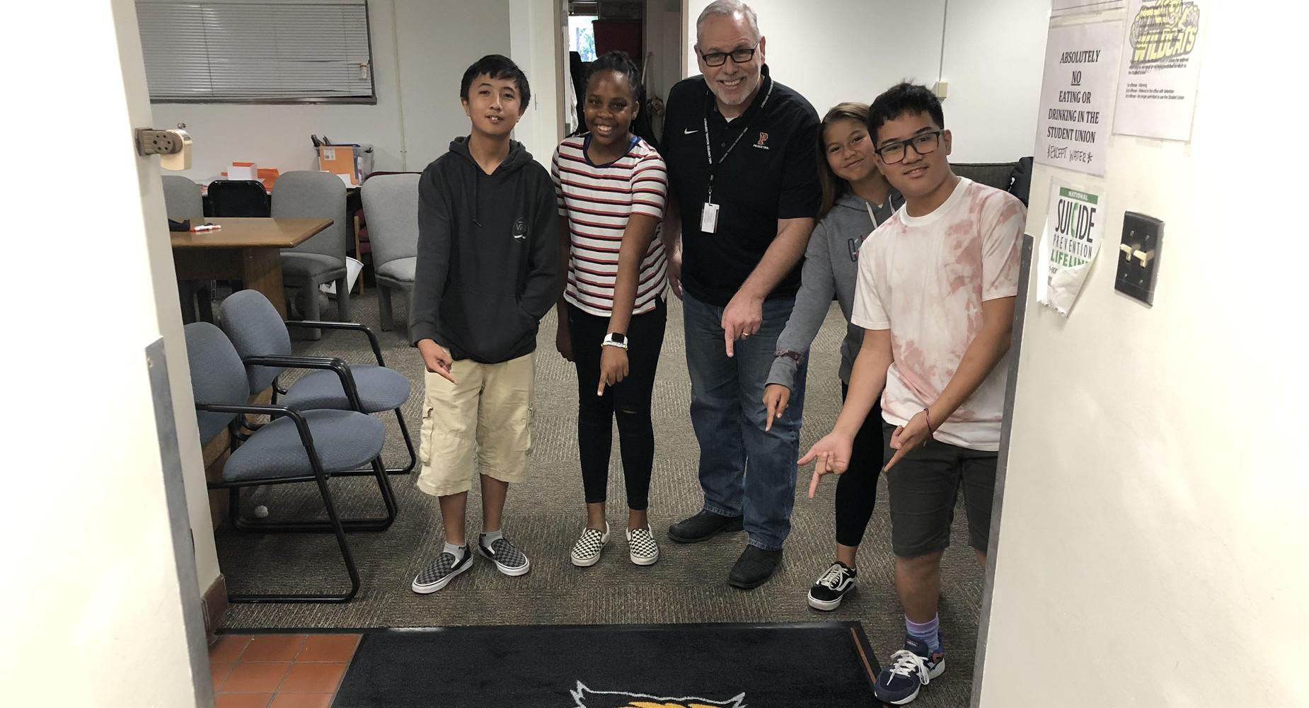 Mr. Briquelet and some students pointing out new WHS welcome mat