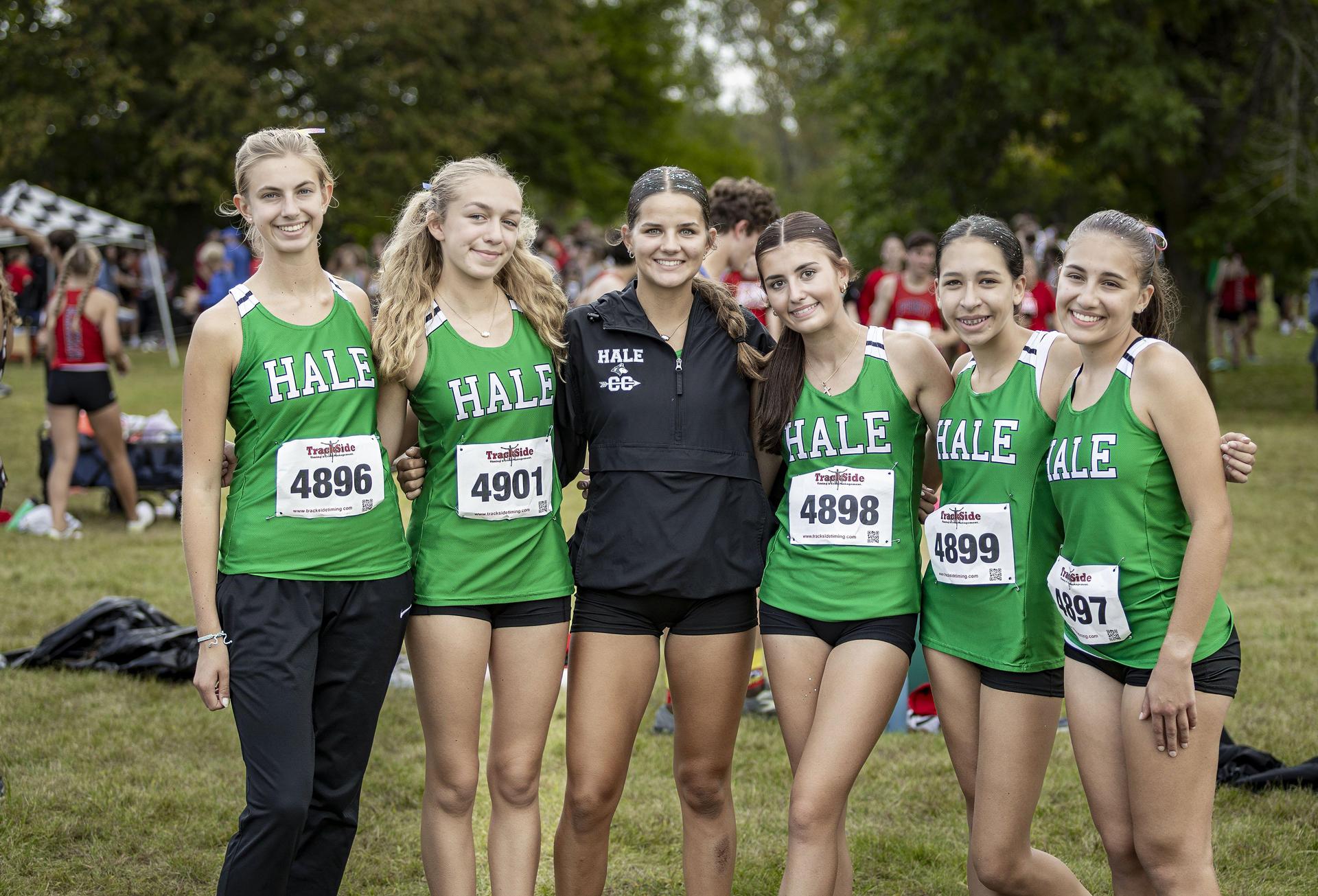 Girls cross country team smiling for a photo