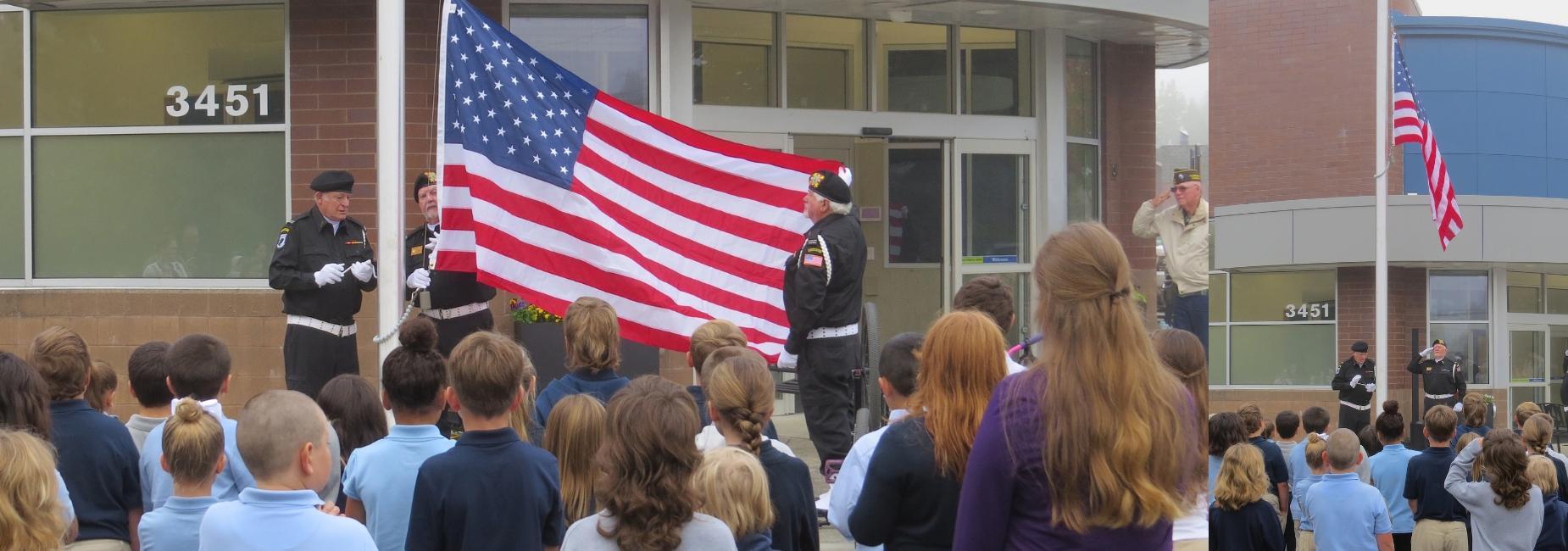 A group of students and veterans at a flag ceremony outside a school.