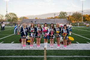group of cheerleaders standing on a football field