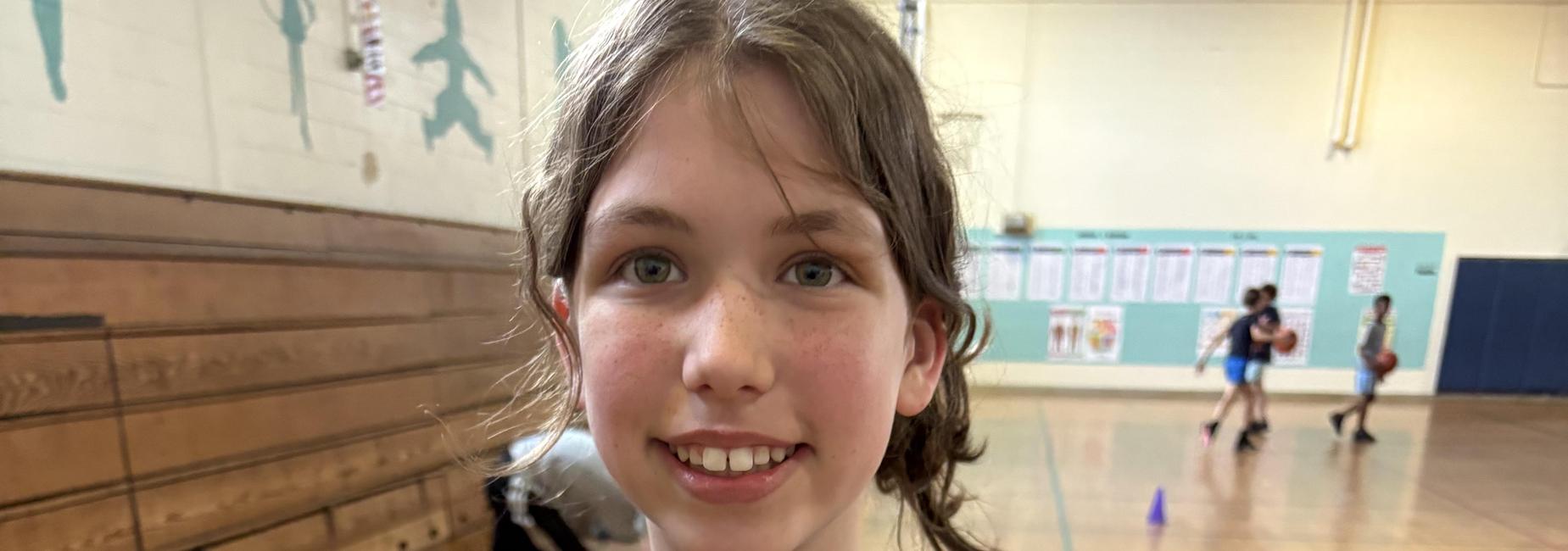 A close-up of a child wearing a blue and black tie-dye shirt.