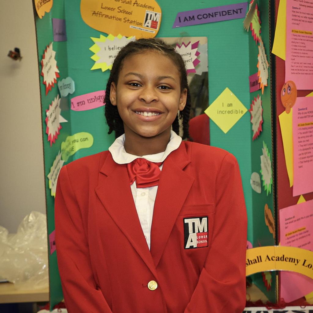 Student in blazer standing in front of presentation
