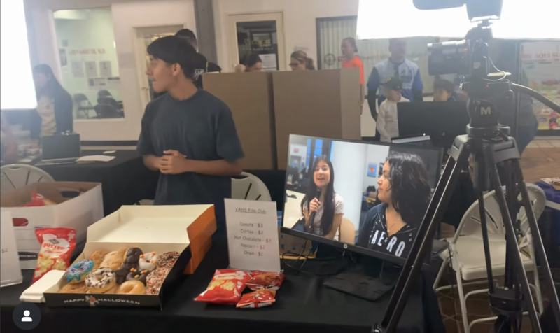 students operate video equipment at a event in the village academy center