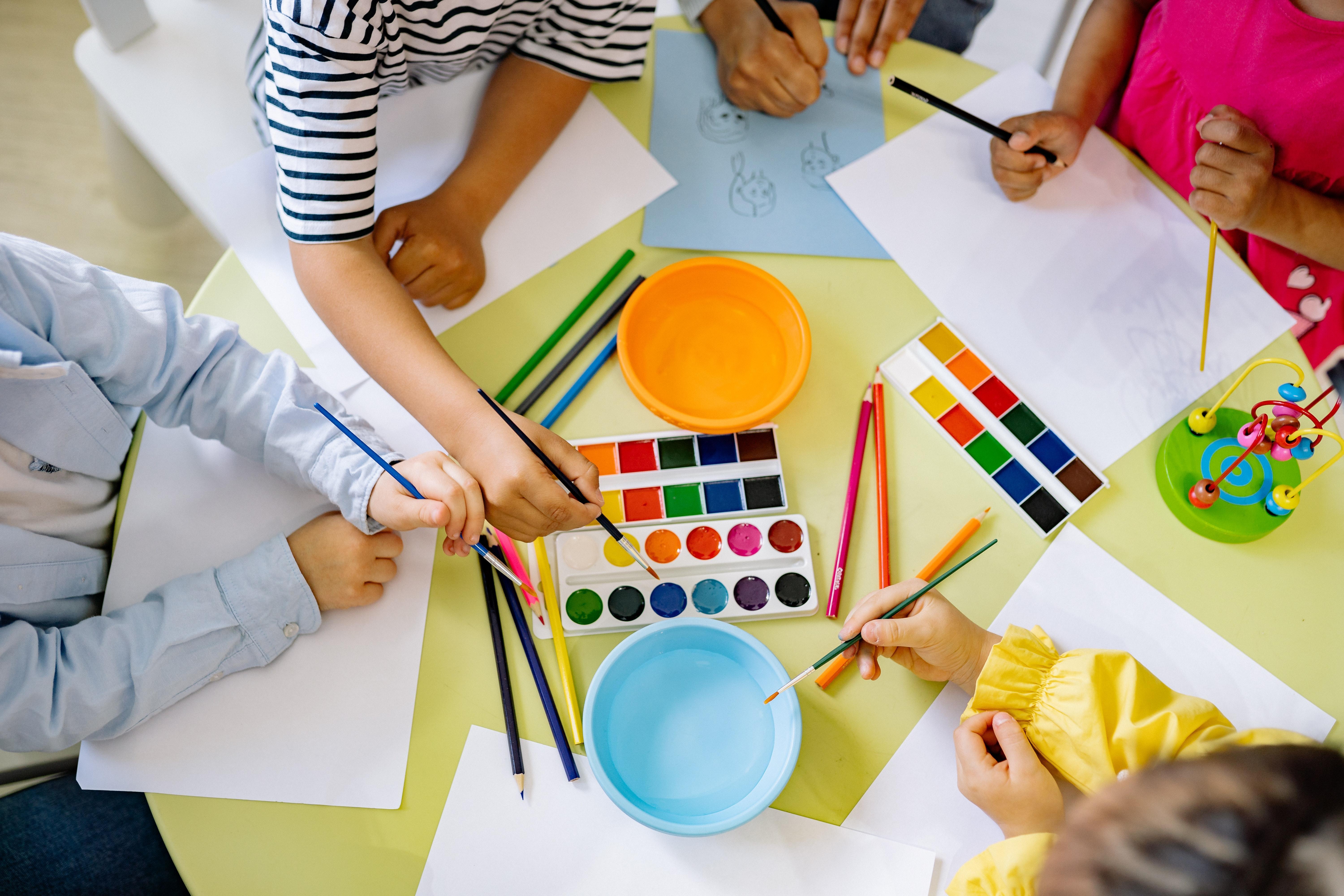 Hands of kids drawing