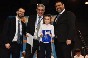 A first grade boy recieves his Siddur