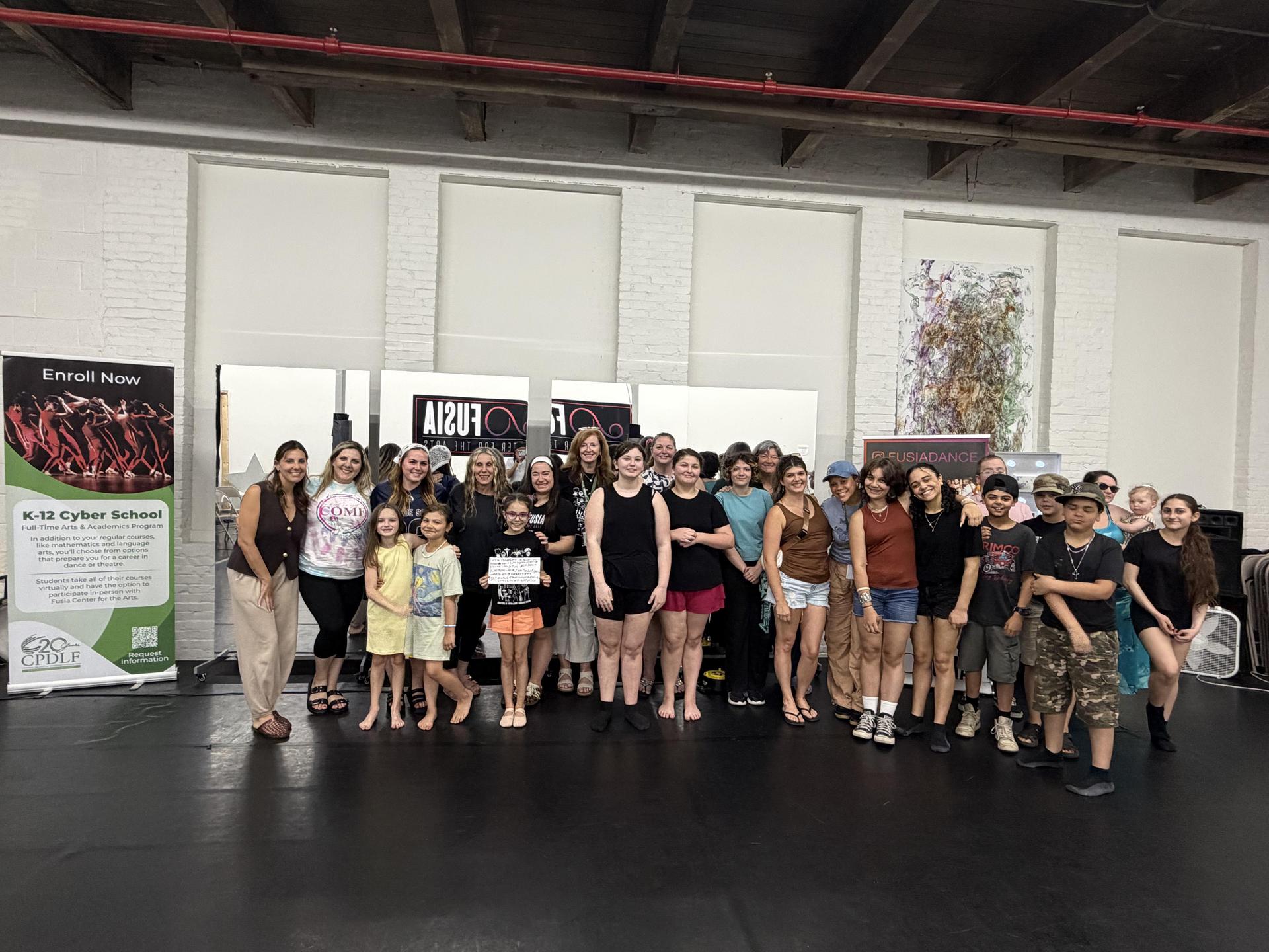 Children and teachers at Fusia Center for the Arts stand in the studio.