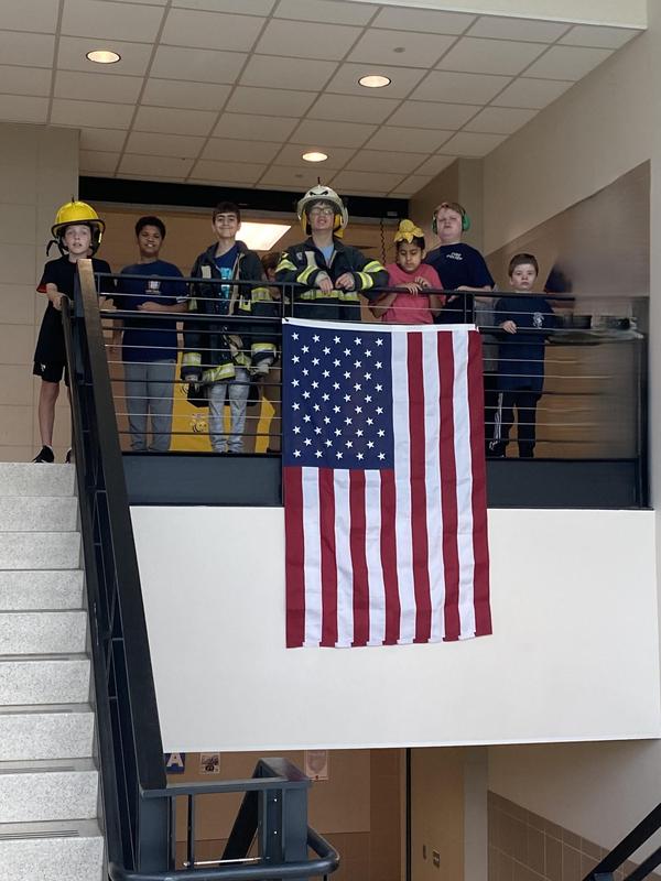 students stand in front of american flag