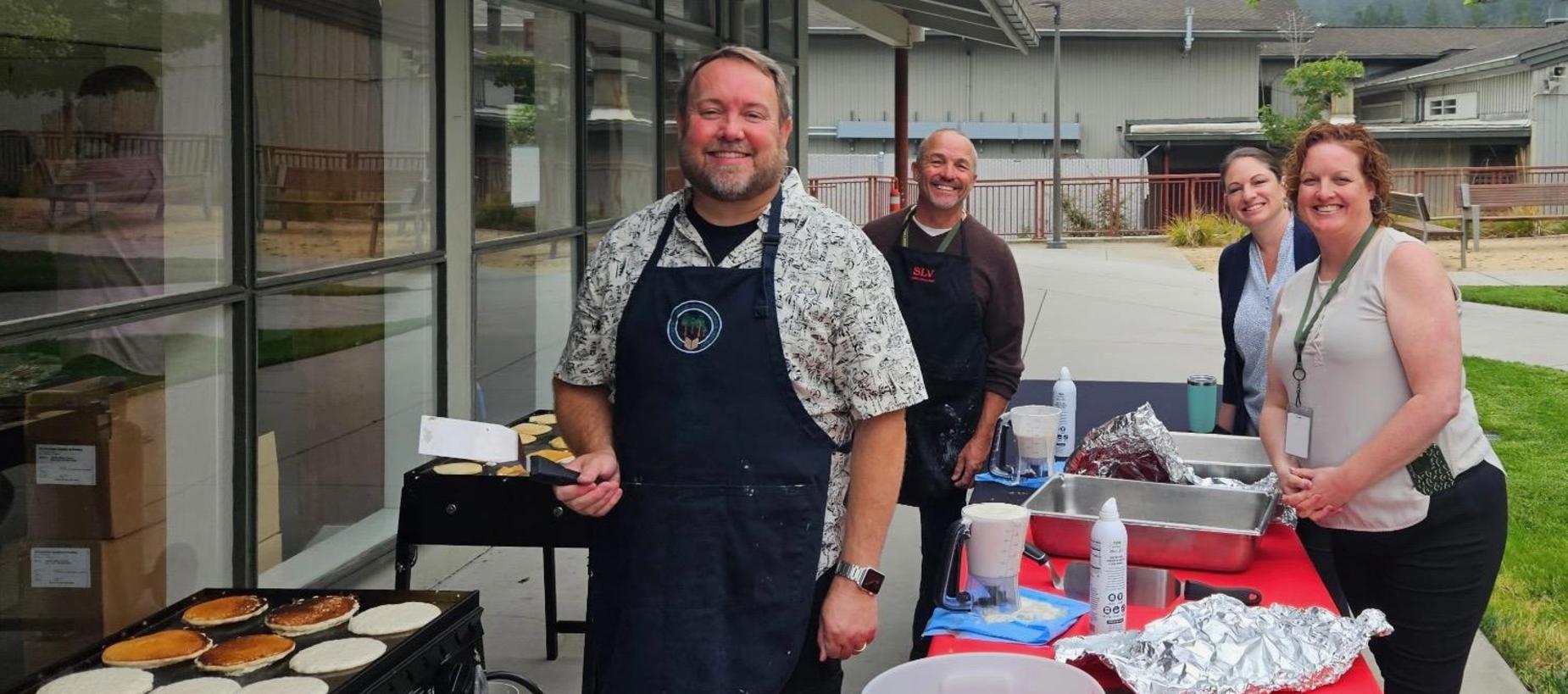 Superintendent and staff flipping pancakes at the 2026 Welcome Back Breakfast.