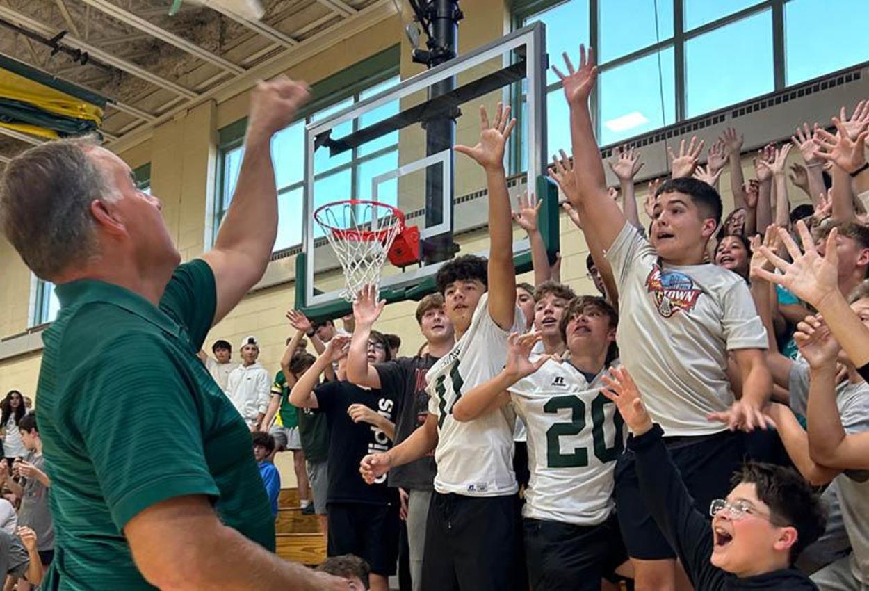 Principal Dr. Cap throws t-shirts into the bleachers during a pep rally at Trafford Middle School