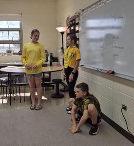 Students act out scenes using the meaning of a word