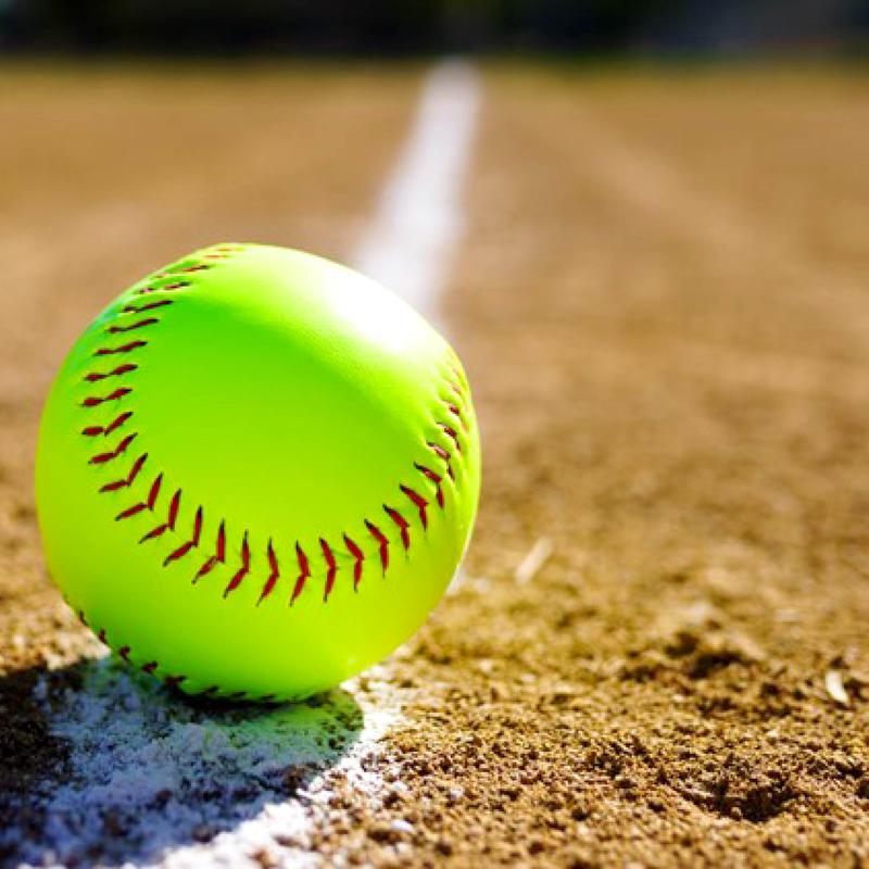 A bright green softball resting on a dirt field.
