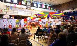 Wide view of gymnasium decorated as circus with crowd in seats