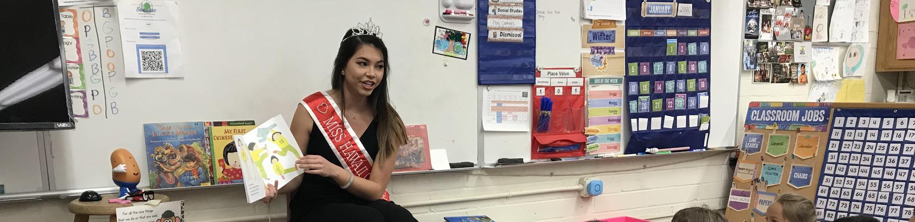Miss Hawaii sharing a book with kindergarteners.