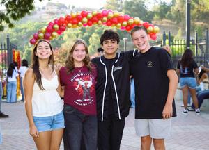 Four Whittier Union students smile for a photo beneath a colorful balloon arch during Freshmen First Day on August 11.