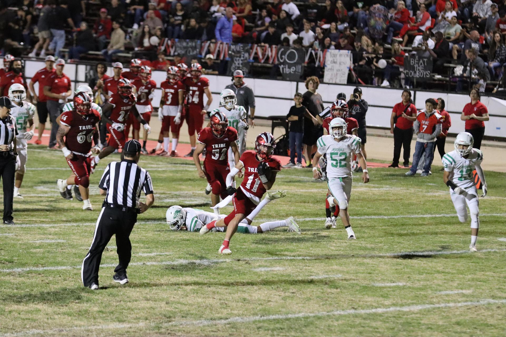 varsity football players in action against Riverdale