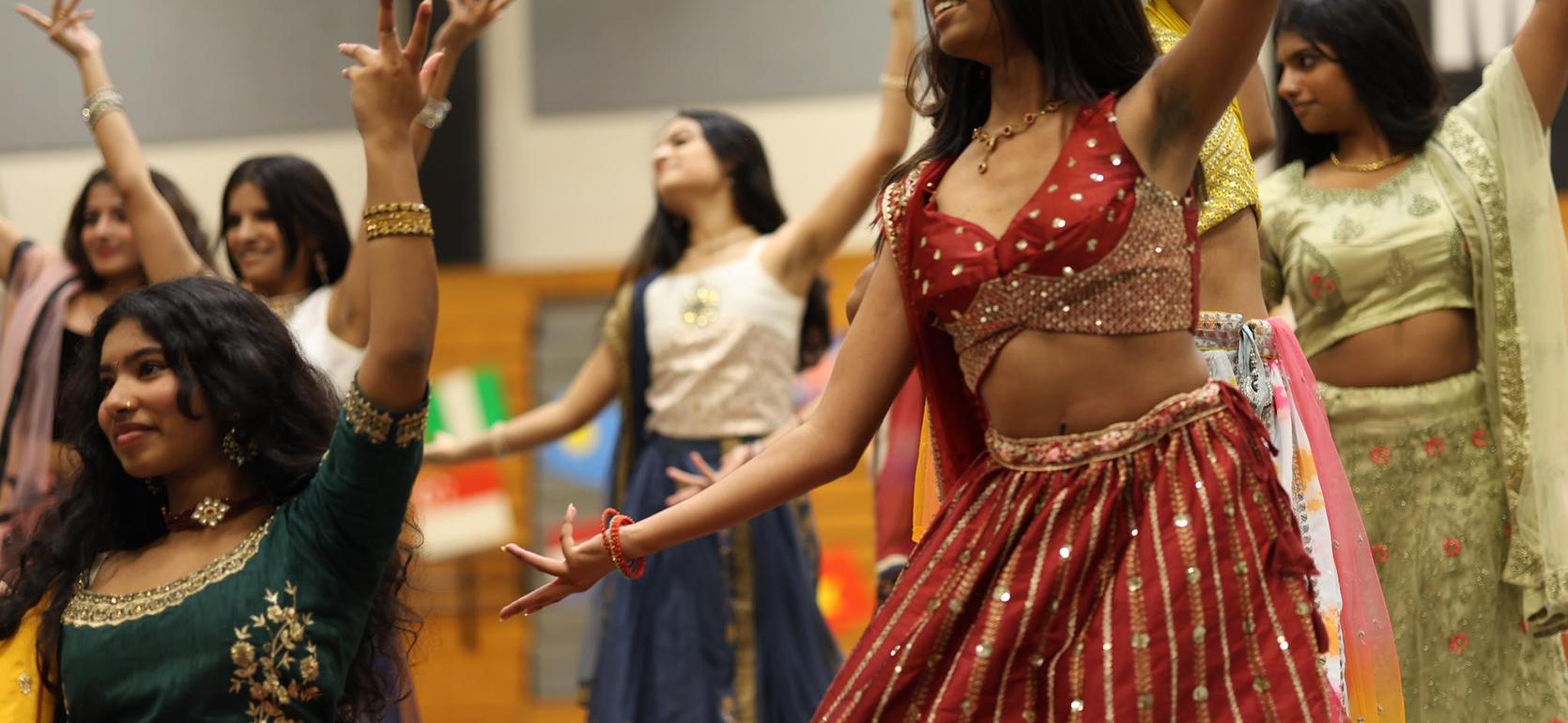 Group of young women performing traditional dance in colorful attire.