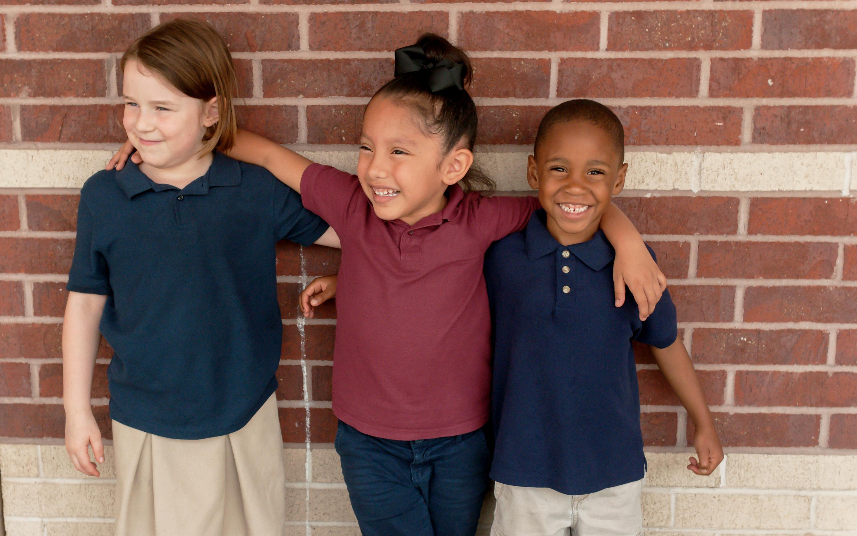 young students standing by a wall