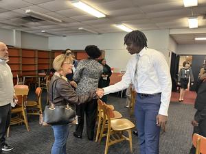student shaking hand with woman