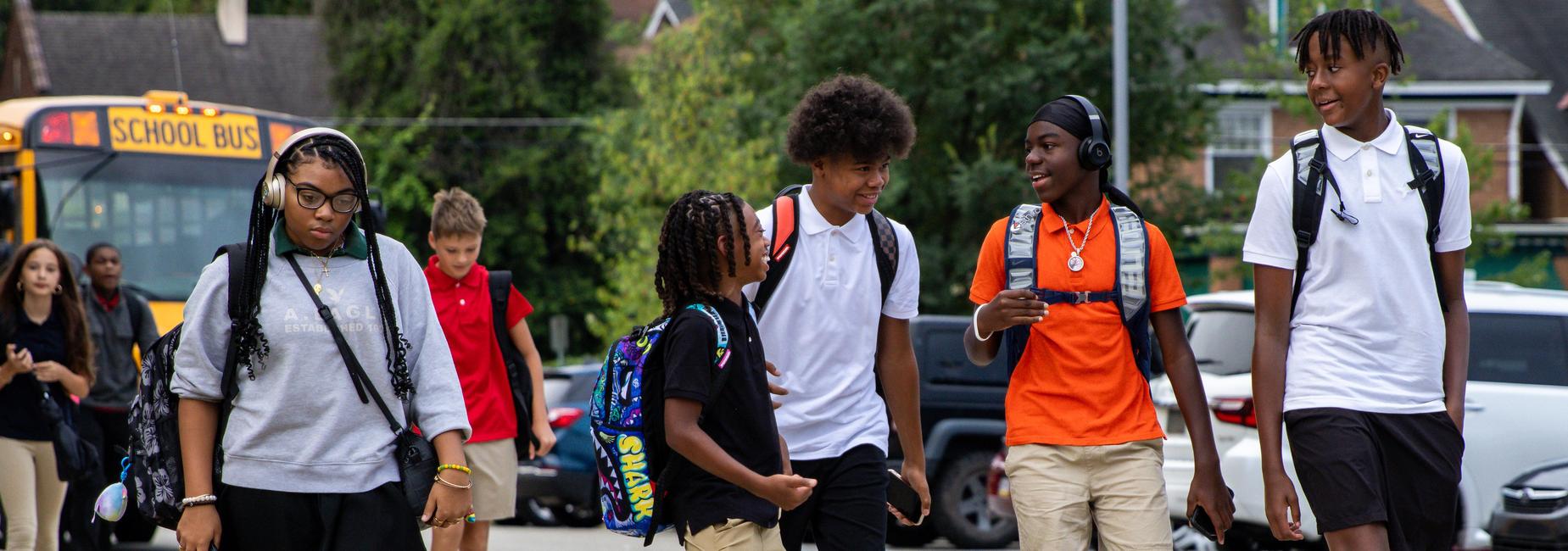 Middle school students laugh and talk as they walk to school