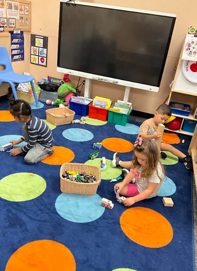 Three students playing with toys