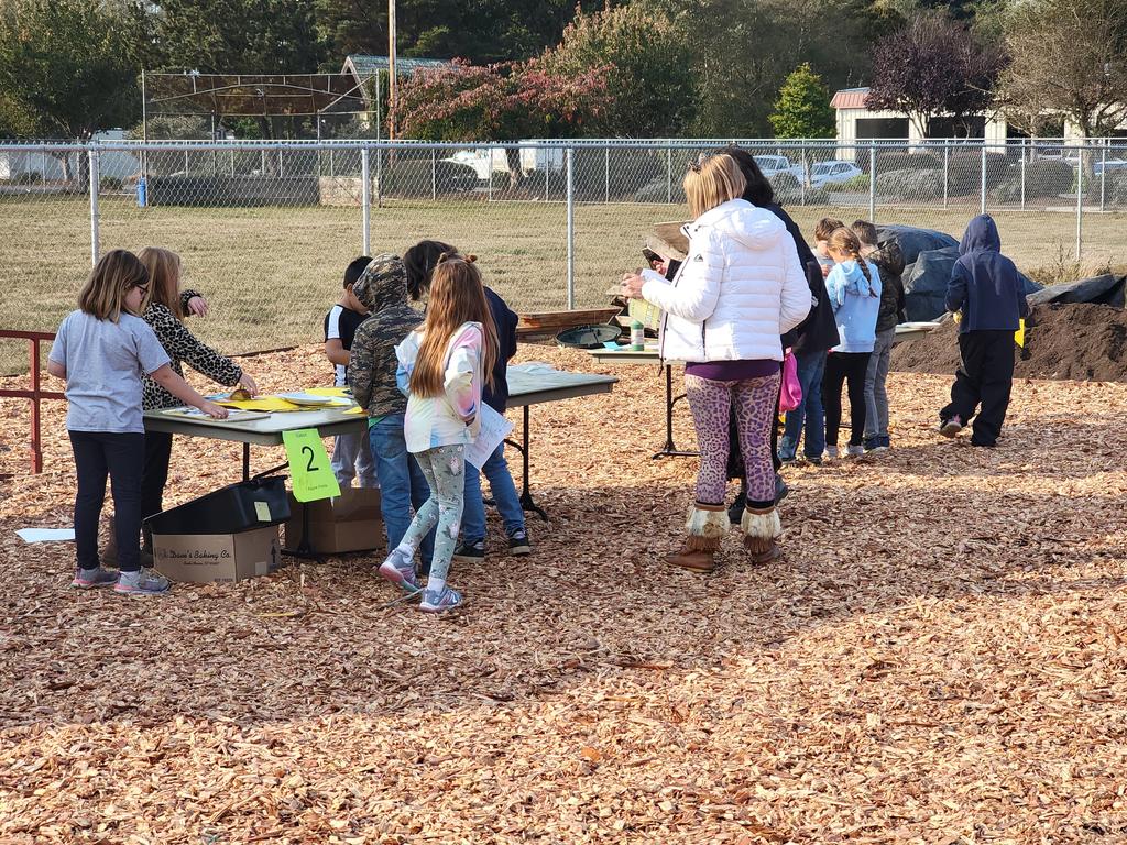 students and helpers at table in garden