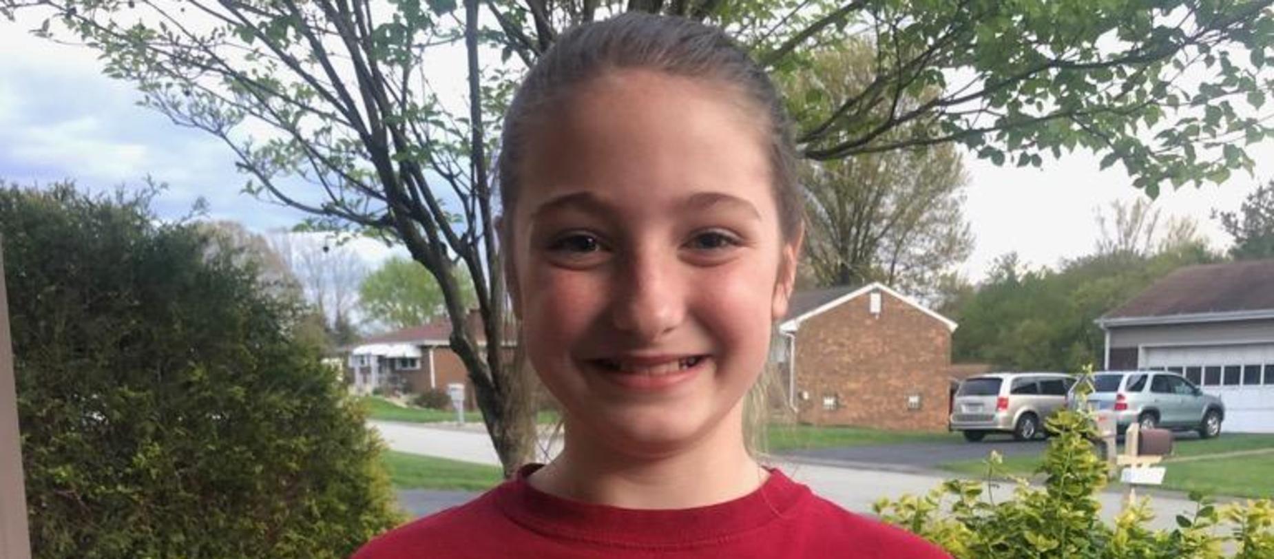 girl standing outside smiling for the camera