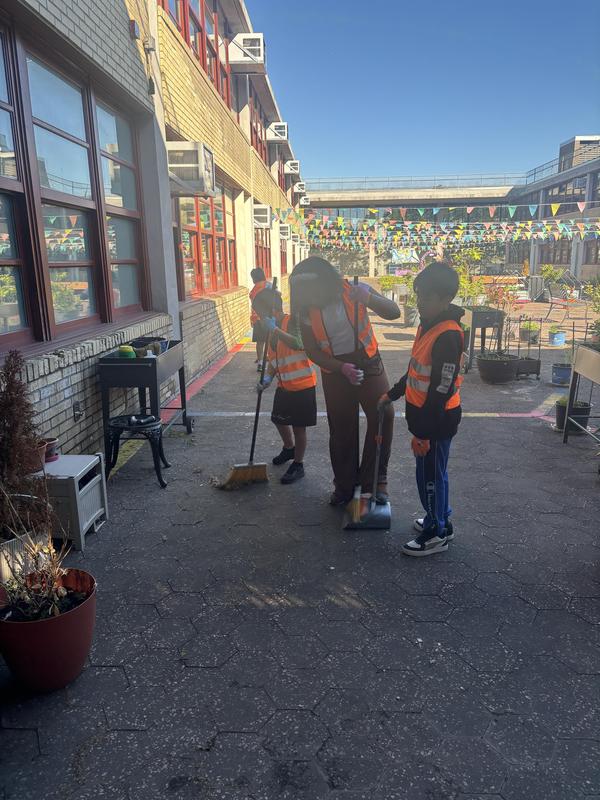 Student sweeping in the courtyard of Hope